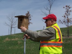 La Crosse County Solid Waste Director Henry Koch inspects one of the many bird houses installed at the landfill. Creating habitat for native species such as birds and snakes. as well as installing and improving native vegitation, are key parts of the county's master land use plan for the ecologically diverse site.