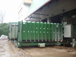 An enclosed roll-on/off hooklift container attached to the aperture of one of the three Kiggen static compactors at the Finikas waste transfer station.