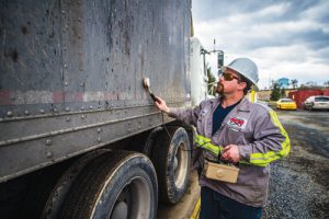 Glenn Landon, a utility operator for Berks Transfer, hand scanning a tractor trailer filled with waste to check for radiation. 